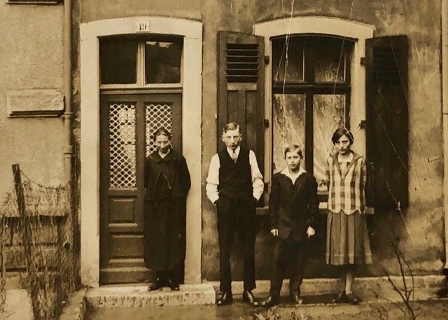 Opferbiografie Johann Josef Becker, Foto mit Mutter, jüngerem Bruder und Schwester vor dem Elternhaus